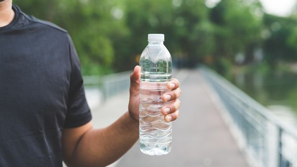 homme en ligne tenant une bouteille d'eau
